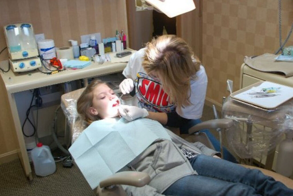 Doctor examining child patient within Remmers Dental